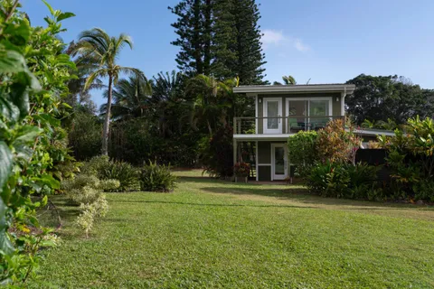 a view of a wooden house with a small yard