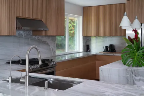 a kitchen with granite countertop a stove a sink and a microwave