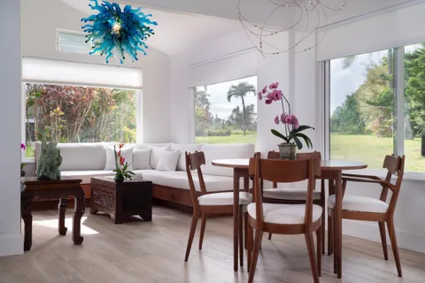 a dining room with furniture a rug and a potted plant