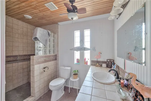 a bathroom with a granite countertop toilet sink and mirror