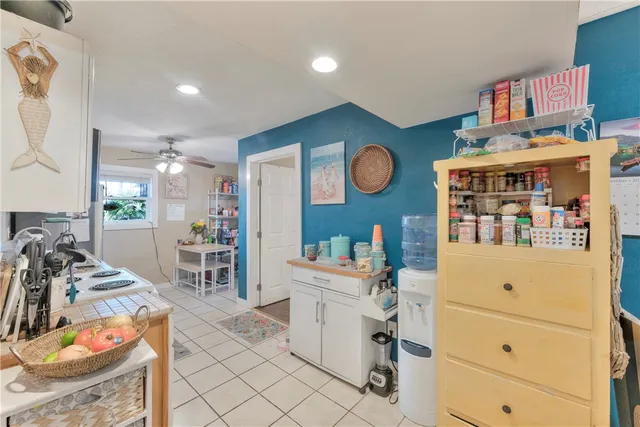 a room with furniture a clock and a view of kitchen