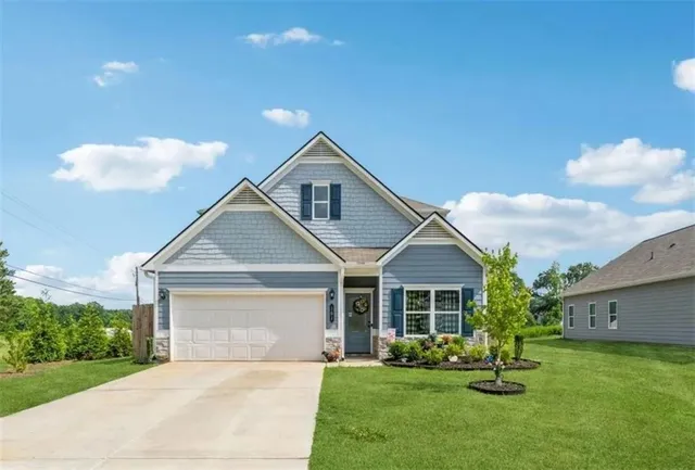 a front view of a house with a garden and yard