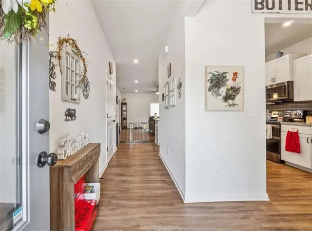 a hallway with painting on the wall and a potted plant