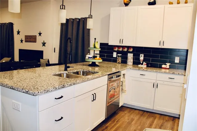 a kitchen with stainless steel appliances kitchen island granite countertop a sink and cabinets