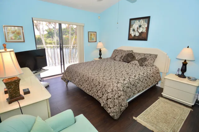 a bedroom with a bed window and a flat screen tv