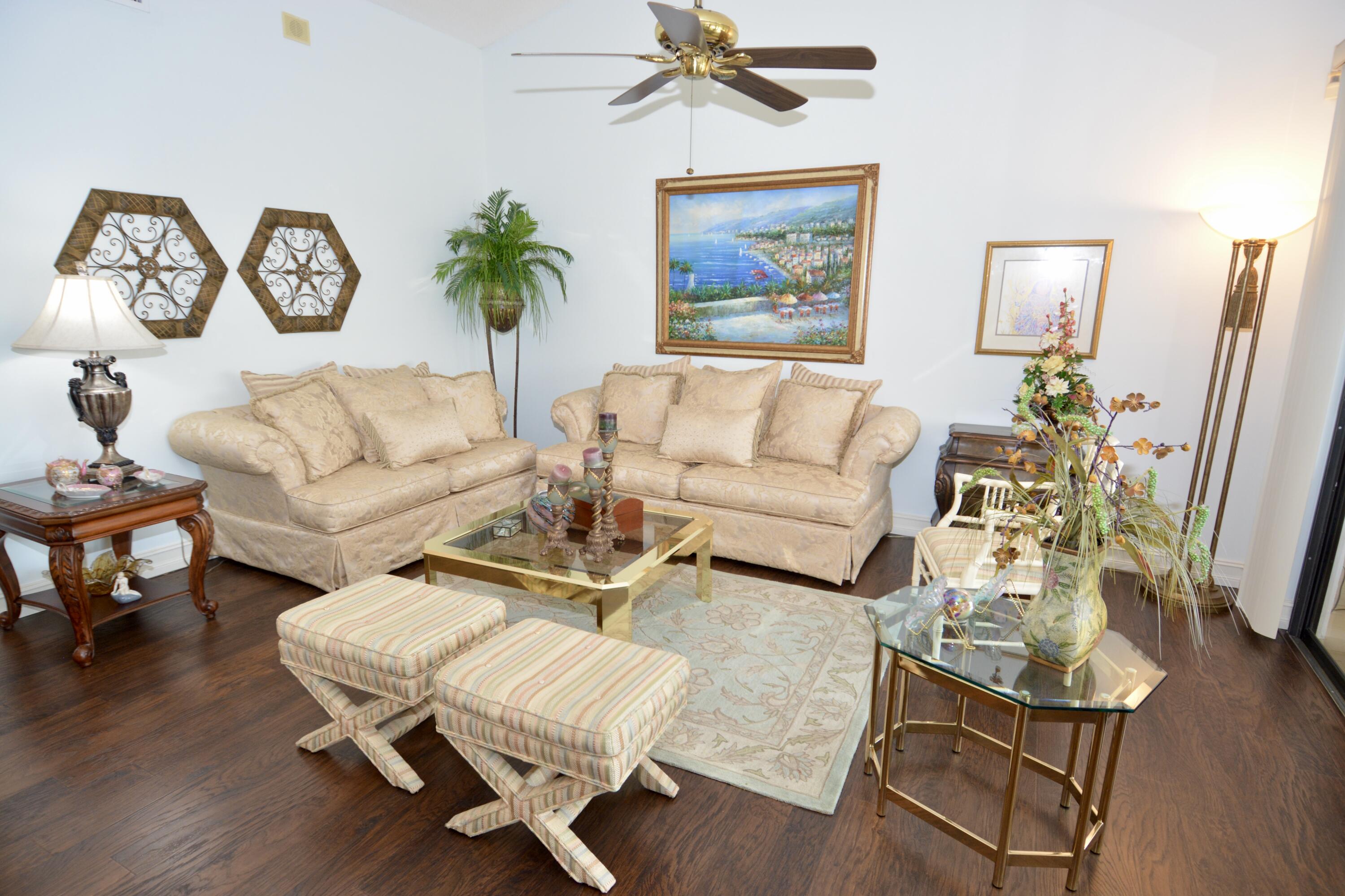 8336 Waterline Drive, Unit 201 Boynton Beach, FL 33472 - Photo 10 of 23 a living room with furniture a rug potted plant and wooden floor