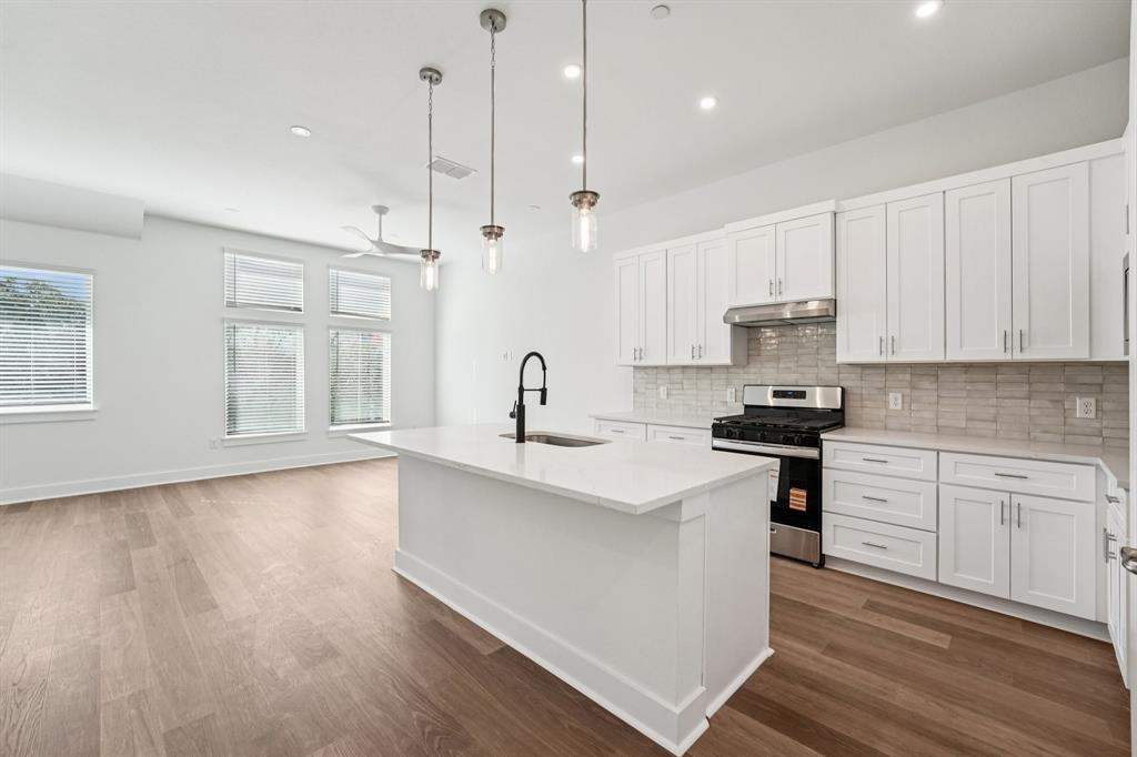 200 West 56th Street, Unit 8101 Austin, TX 78751 - Photo 8 of 13 The kitchen is the heart of the living space, featuring a large quartz island and stylish pendant lights hanging above. (Sample photo of finishes and layout)