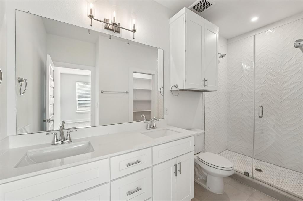 200 West 56th Street, Unit 8101 Austin, TX 78751 - Photo 10 of 13 Fresh and bright, the primary bath features A dual quartz vanity and a walk-in shower with textured herringbone tile for a little extra style.(Sample photo of finishes and layout)