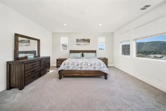 a bedroom with a large bed and dresser