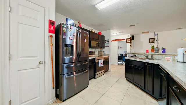 a kitchen with stainless steel appliances granite countertop a refrigerator and a stove