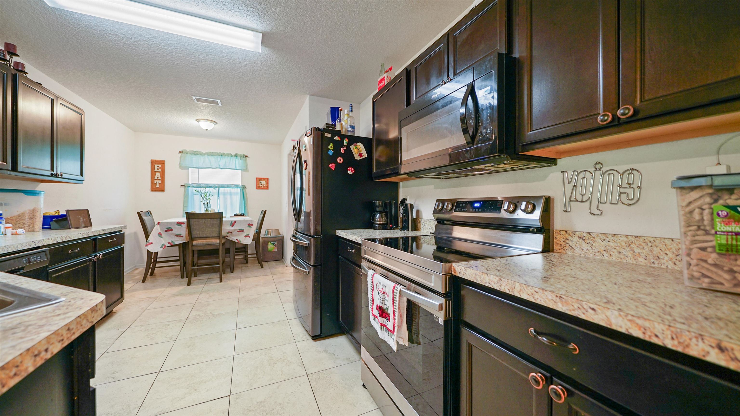 77102 Crosscut Way Yulee, FL 32097 - Photo 7 of 21 a kitchen with stainless steel appliances granite countertop a sink stove and cabinets