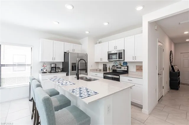 a kitchen with stainless steel appliances a refrigerator sink and microwave