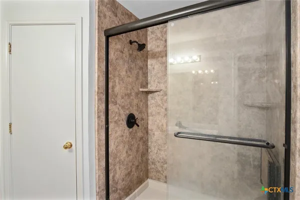 a bathroom with a glass shower door