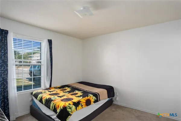 a bed sitting in a bedroom next to a window