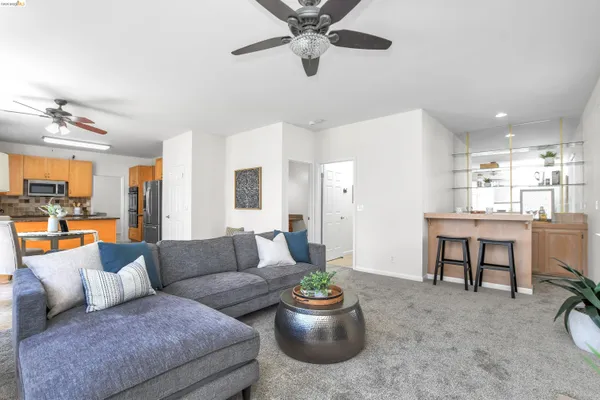 a living room with furniture and a view of kitchen