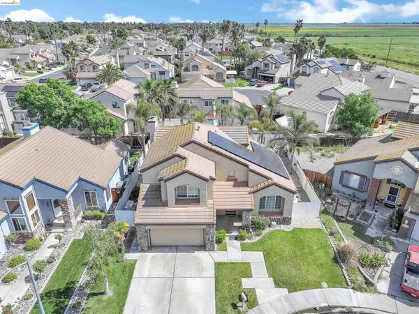 an aerial view of residential houses with outdoor space and parking
