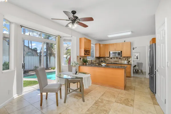 a view of a dining room kitchen with furniture a livingroom and chandelier