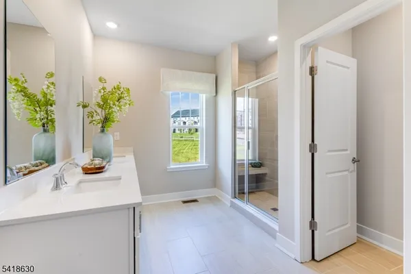 a bathroom with a sink a mirror and a shower