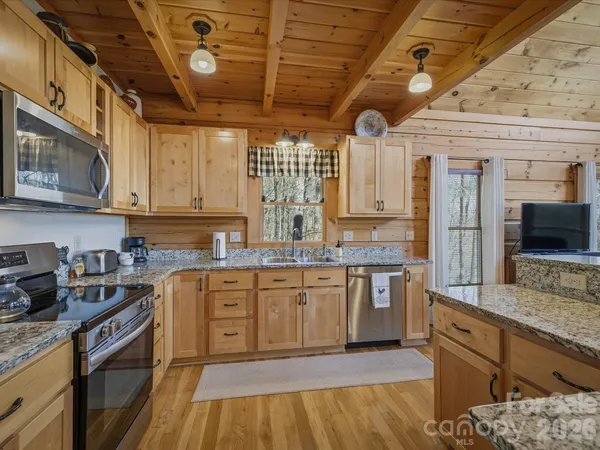 a spacious bedroom with a bed and wooden floor