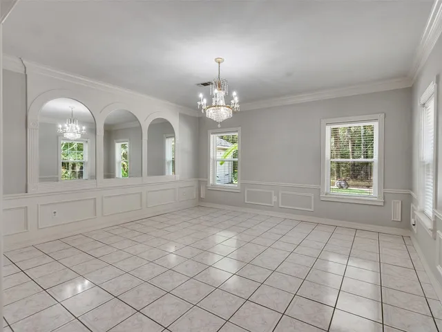 an empty room with windows and chandelier