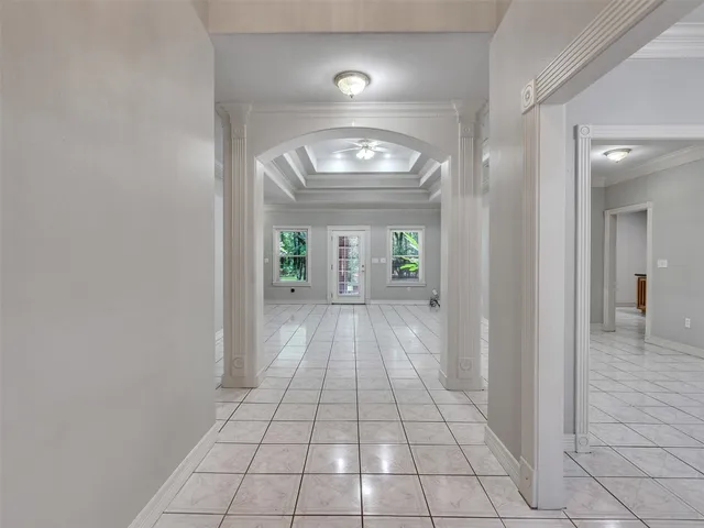 a view of a hallway with wooden floor and a chandelier