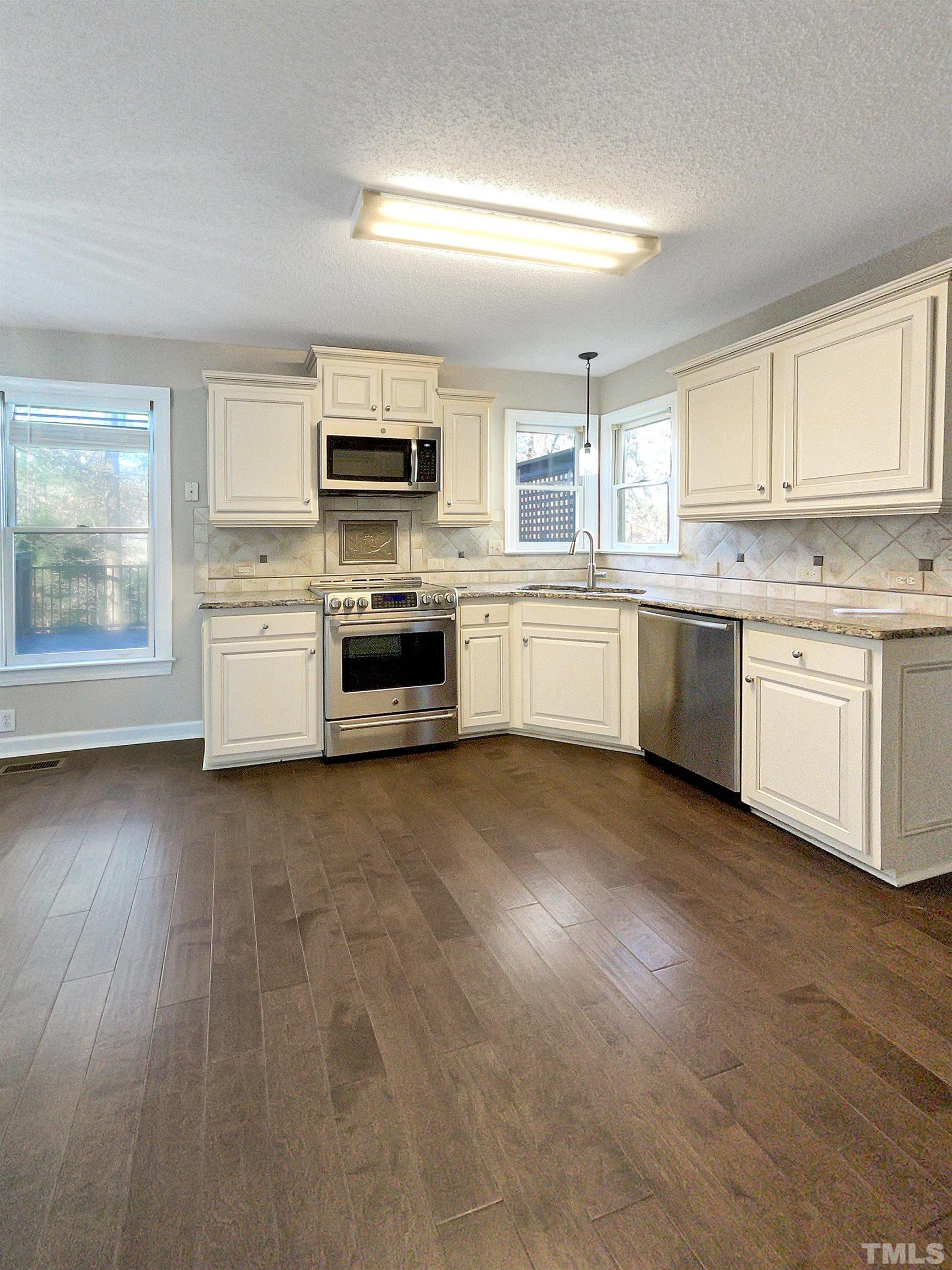 6017 Tarleton Court Raleigh, NC 27616 - Photo 2 of 26 a large kitchen with granite countertop lots of counter top space sink and stainless steel appliances