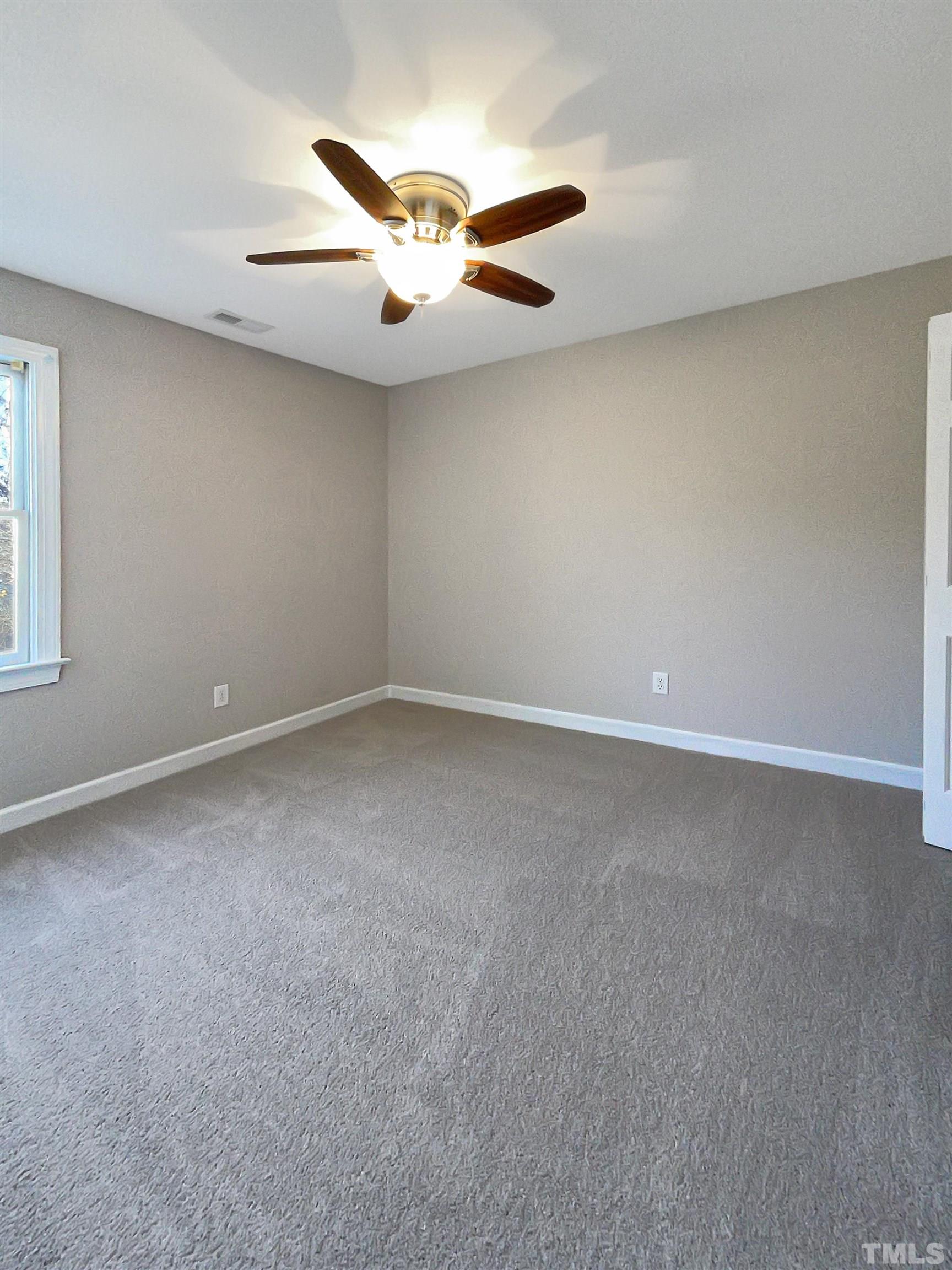6017 Tarleton Court Raleigh, NC 27616 - Photo 12 of 26 an empty room with windows and fan