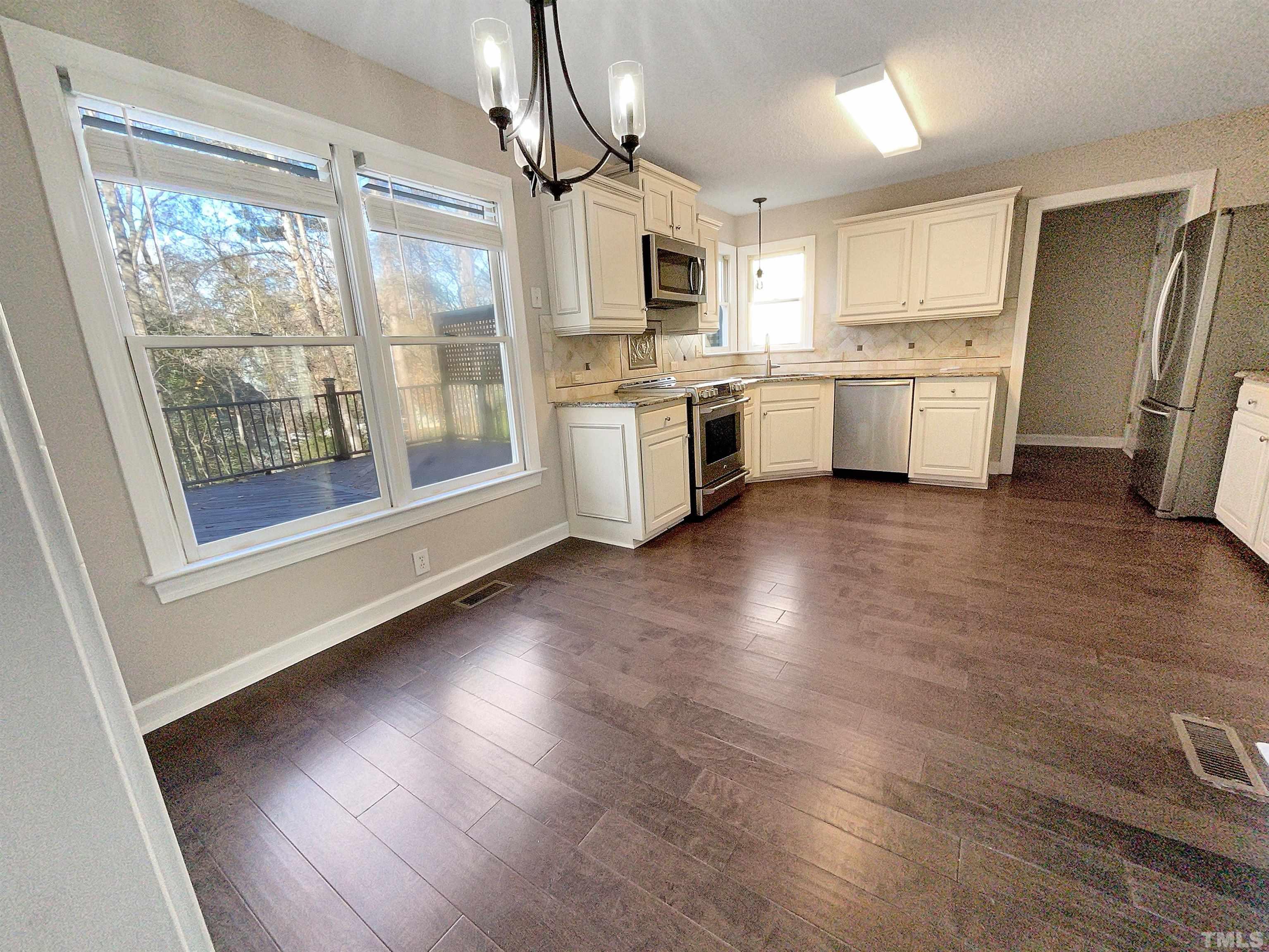 6017 Tarleton Court Raleigh, NC 27616 - Photo 24 of 26 a kitchen with a refrigerator a stove top oven and white walls
