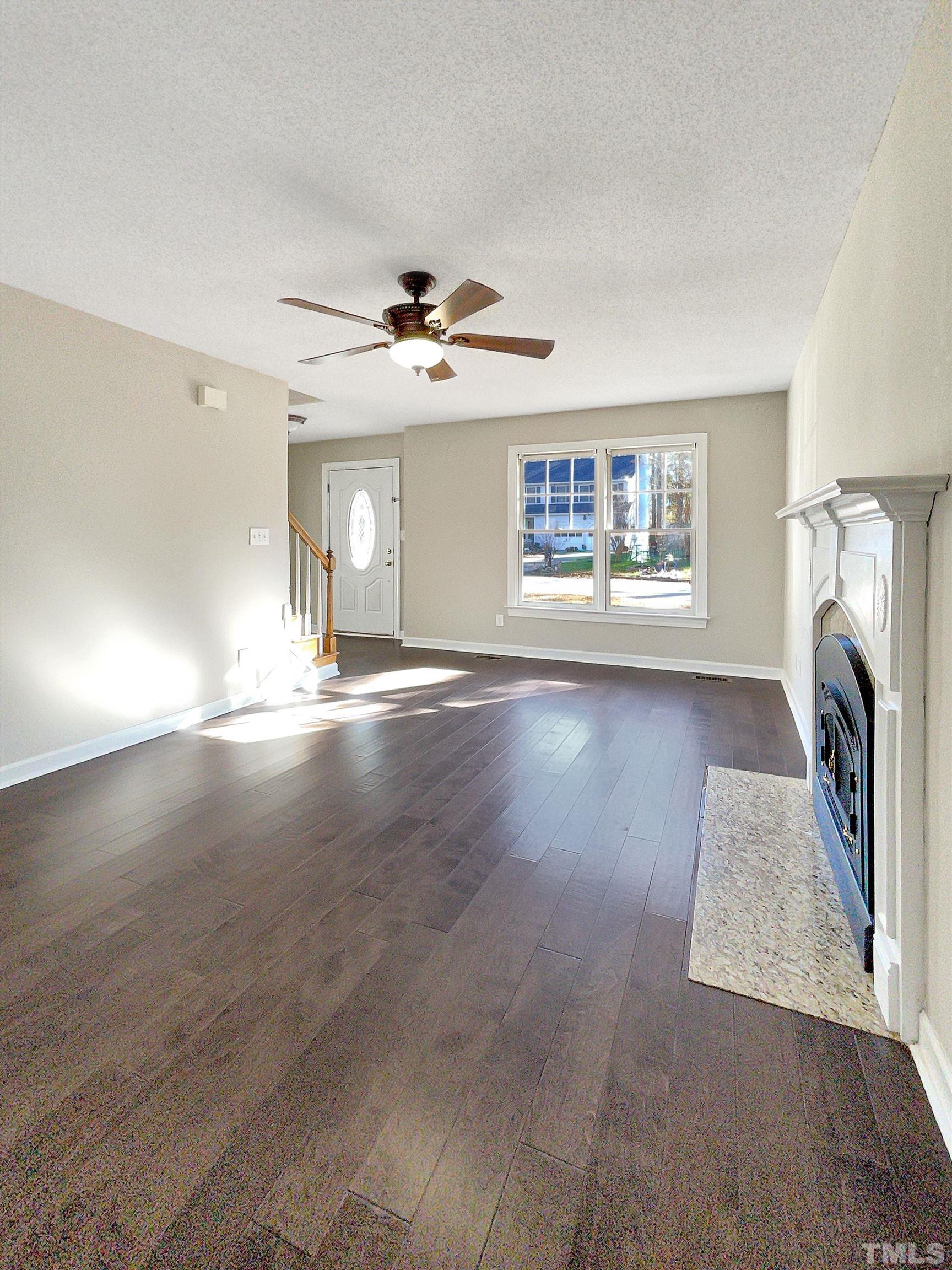 6017 Tarleton Court Raleigh, NC 27616 - Photo 6 of 26 wooden floor in an empty room with a fireplace