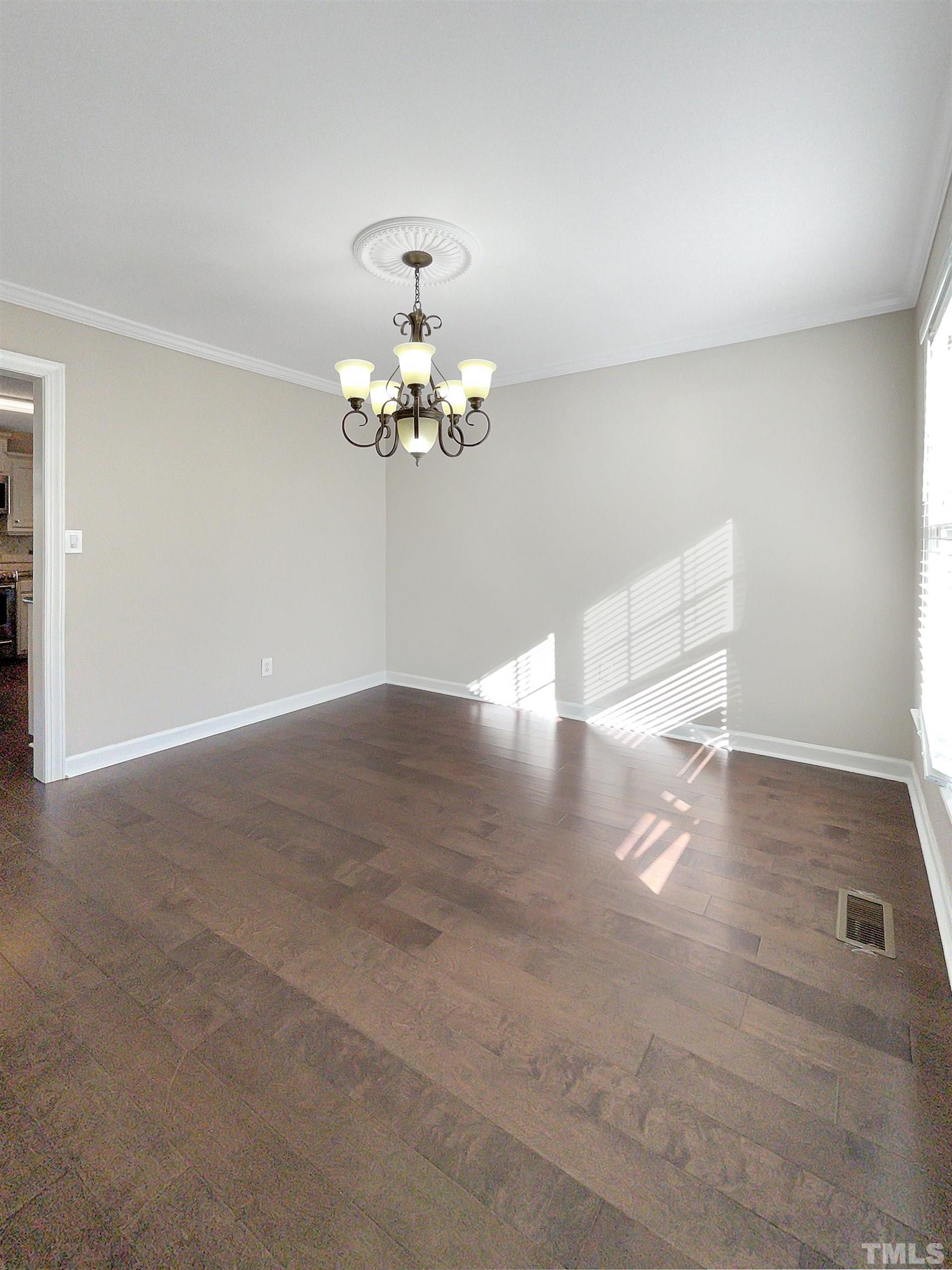 6017 Tarleton Court Raleigh, NC 27616 - Photo 10 of 26 a view of a room with wooden floor and chandelier