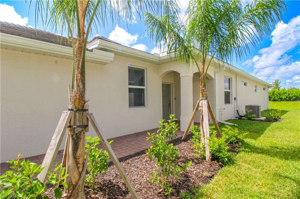 2156 Dragonfruit Way Naples, FL 34120 - Photo 13 of 50 View of front of house with a patio area and a front lawn
