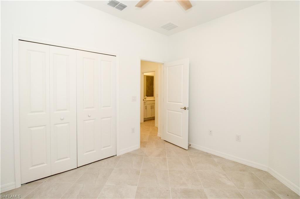 2156 Dragonfruit Way Naples, FL 34120 - Photo 27 of 50 Unfurnished bedroom featuring a closet, ceiling fan, and light tile patterned floors
