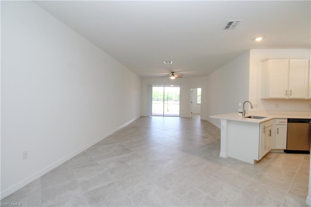 2156 Dragonfruit Way Naples, FL 34120 - Photo 32 of 50 Kitchen featuring white cabinetry, light tile patterned floors, dishwasher, ceiling fan, and sink