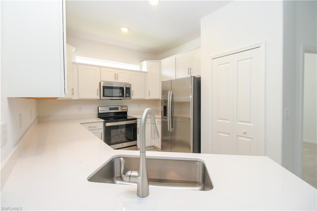 2156 Dragonfruit Way Naples, FL 34120 - Photo 35 of 50 Kitchen with white cabinetry, stainless steel appliances, and sink