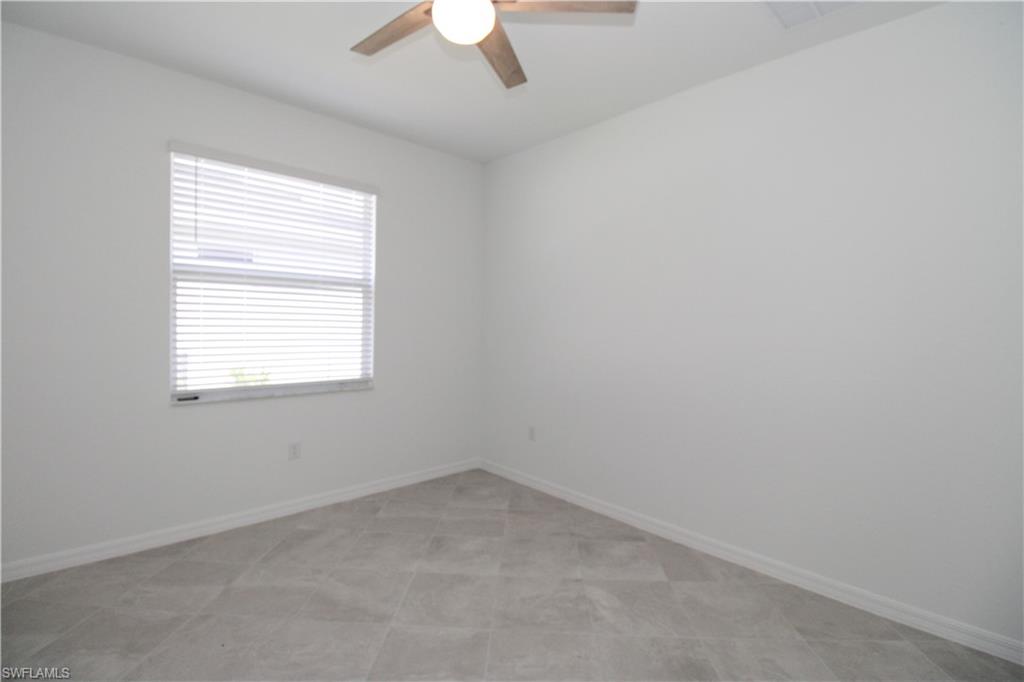 2156 Dragonfruit Way Naples, FL 34120 - Photo 40 of 50 Empty room with light tile patterned floors and ceiling fan