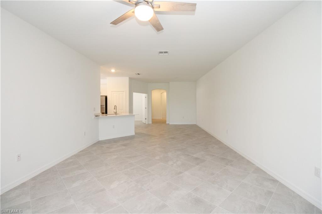 2156 Dragonfruit Way Naples, FL 34120 - Photo 44 of 50 Unfurnished living room featuring sink, light tile patterned floors, and ceiling fan