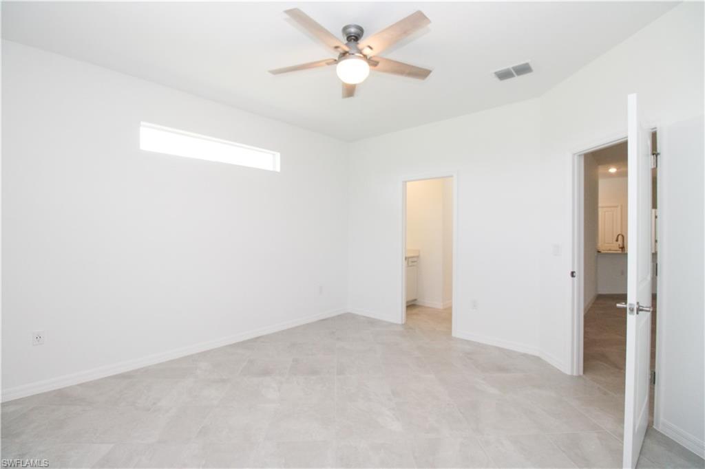 2156 Dragonfruit Way Naples, FL 34120 - Photo 47 of 50 Unfurnished bedroom featuring a closet, a walk in closet, light tile patterned floors, and ceiling fan