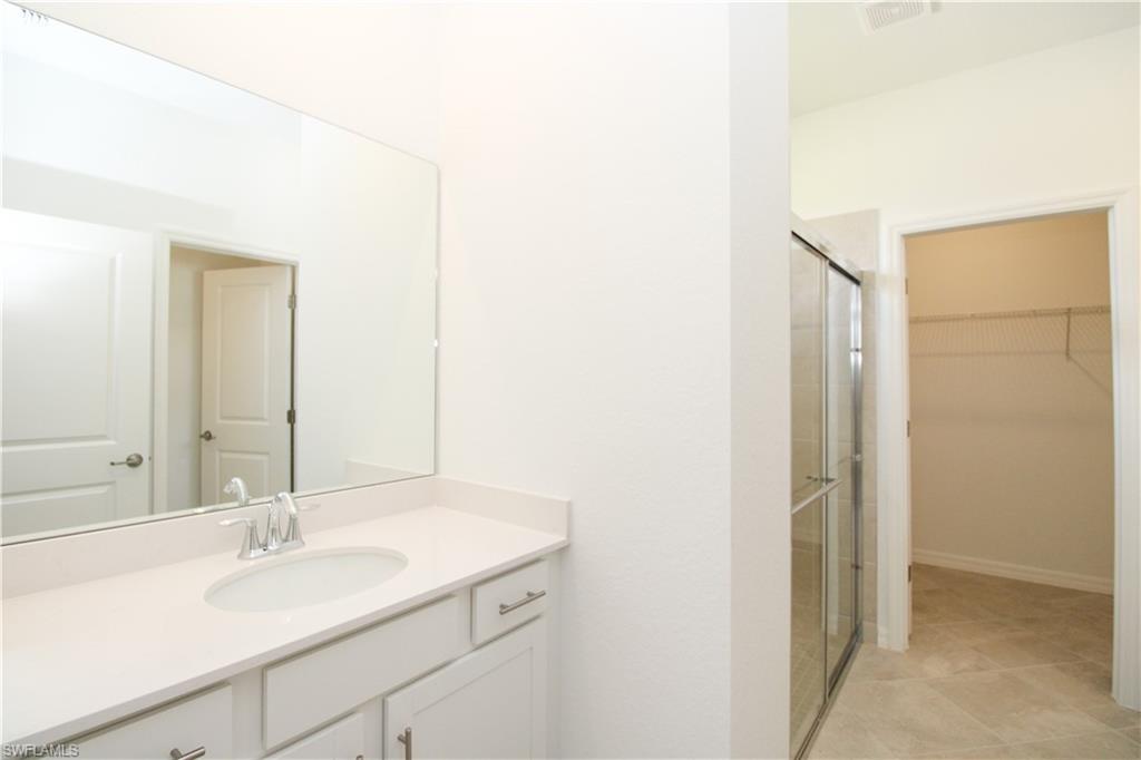 2156 Dragonfruit Way Naples, FL 34120 - Photo 49 of 50 Bathroom with vanity, tile patterned floors, and a shower with door