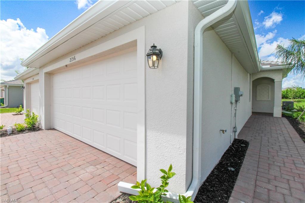 2156 Dragonfruit Way Naples, FL 34120 - Photo 8 of 50 View of side of property featuring a garage