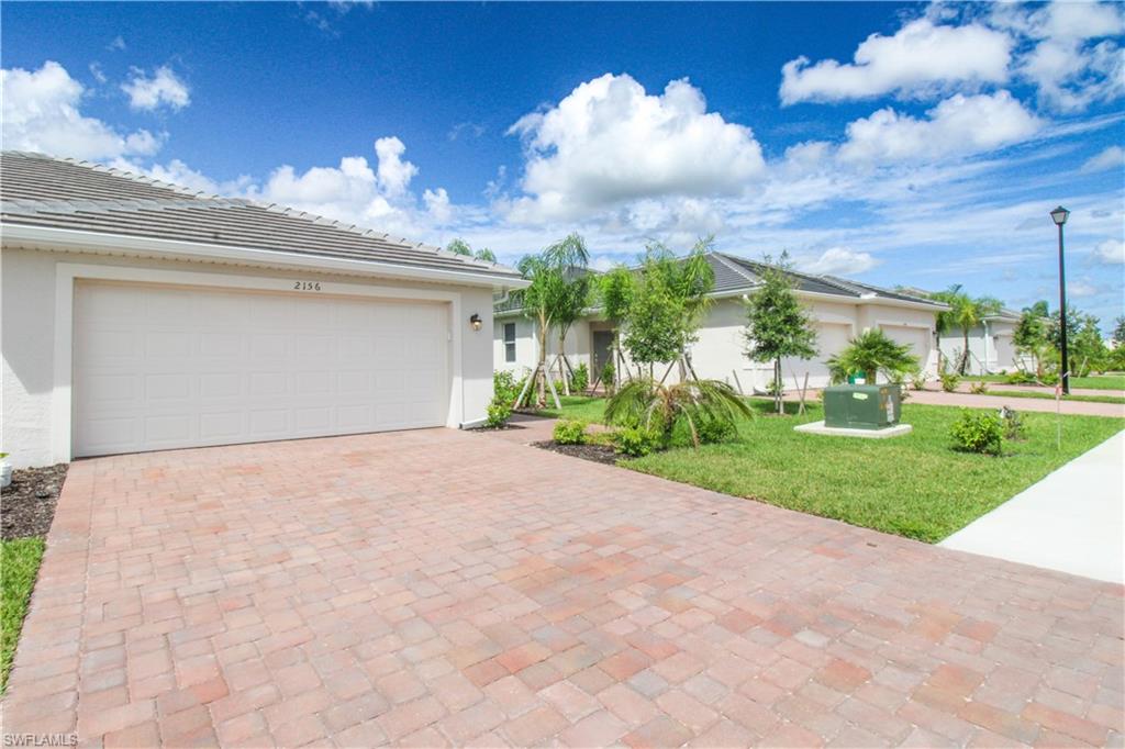 2156 Dragonfruit Way Naples, FL 34120 - Photo 9 of 50 Ranch-style house featuring a garage and a front lawn