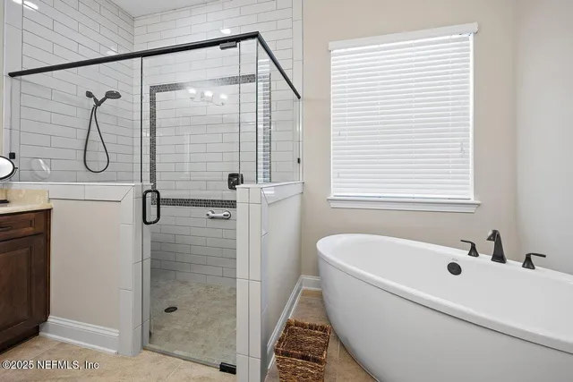 a bathroom with a white bath tub sitting next to a shower