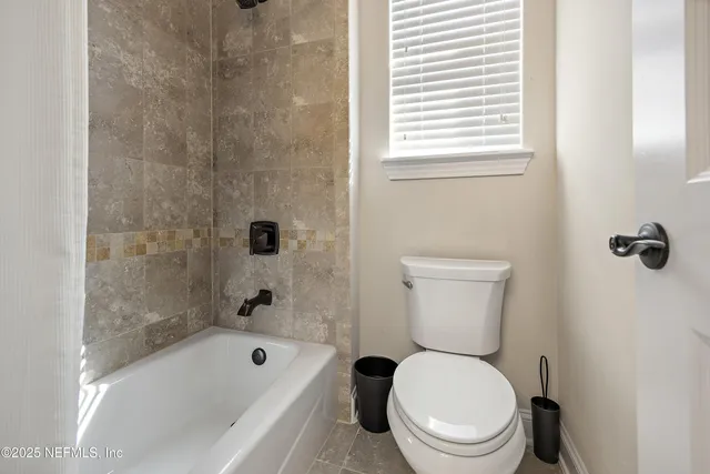 a white toilet sitting next to a bathtub