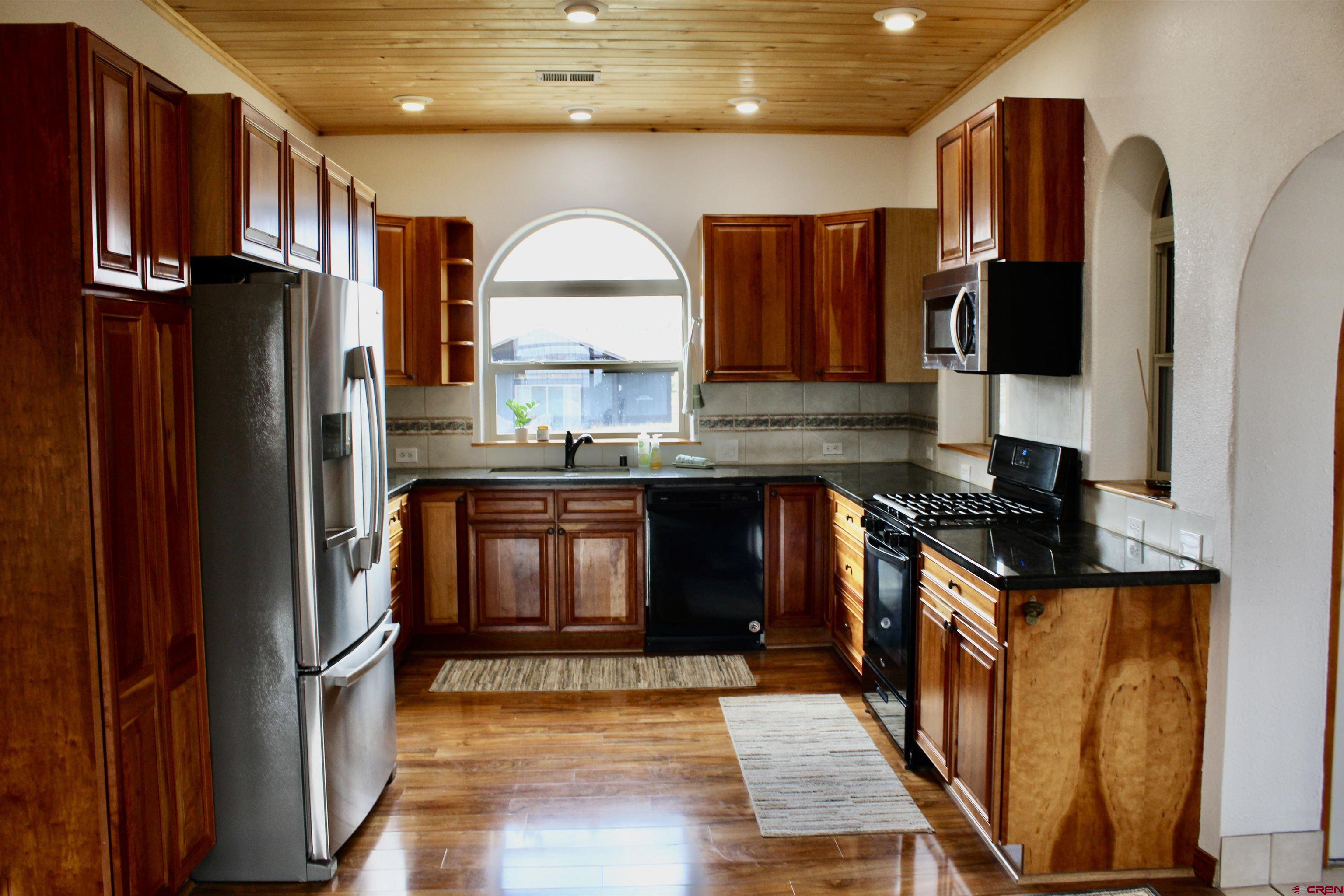 59 Rincon Court Pagosa Springs, CO 81147 - Photo 10 of 37 a kitchen with stainless steel appliances granite countertop a refrigerator a stove a sink and a microwave