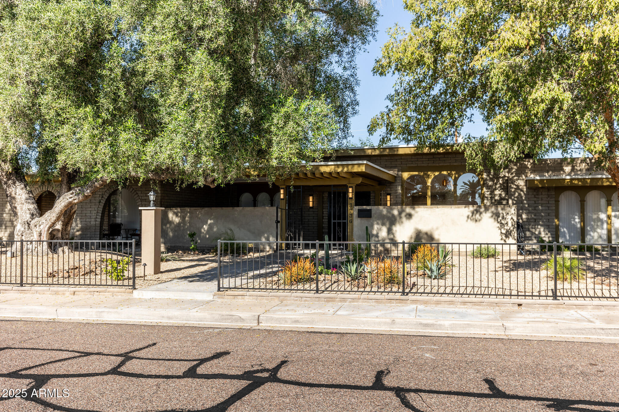 3736 East Montecito Avenue Phoenix, AZ 85018 - Photo 36 of 42 a view of a brick house with large trees and a large tree