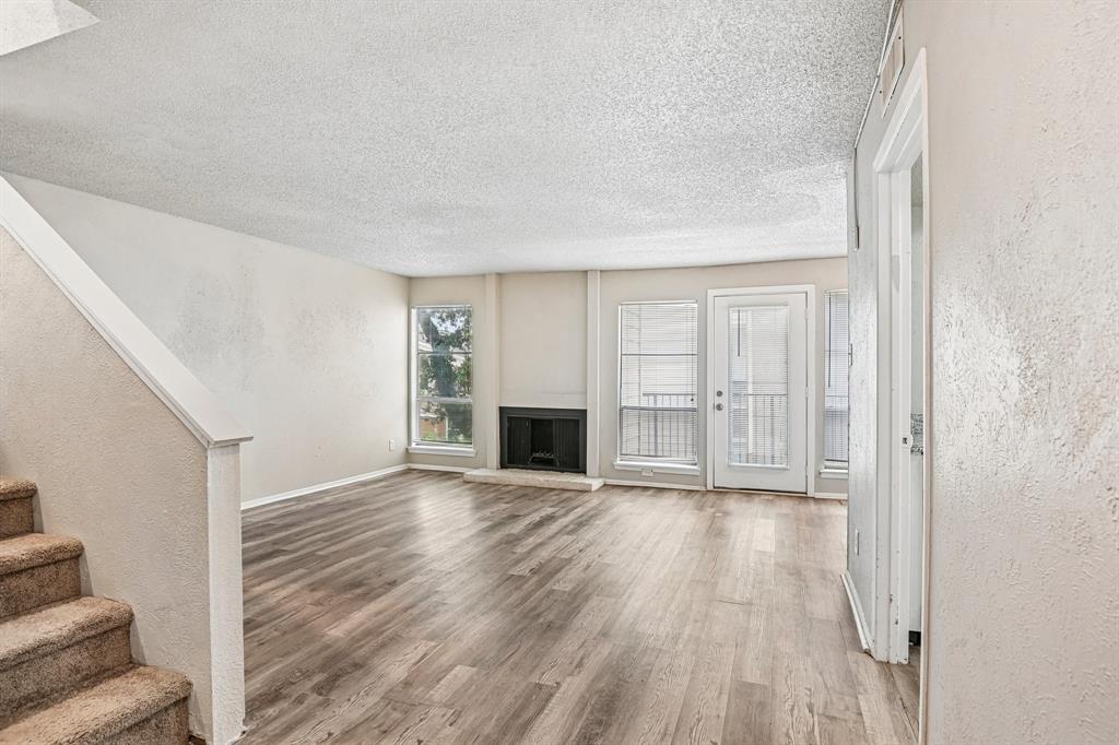 5534 Boca Raton Boulevard, Unit 292 Fort Worth, TX 76112 - Photo 5 of 31 a view of a livingroom with wooden floor and a fireplace