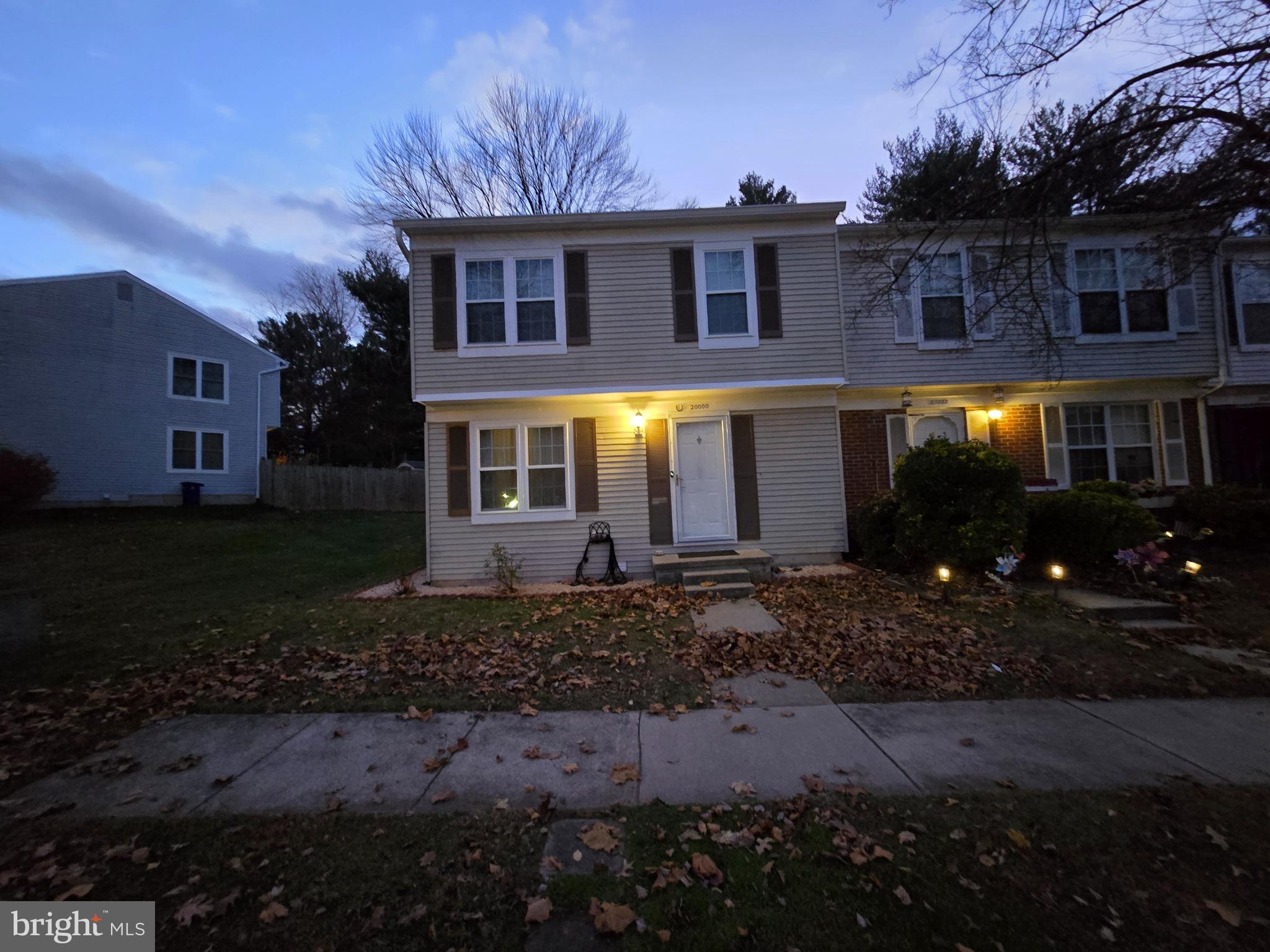 a front view of a house with yard and green space