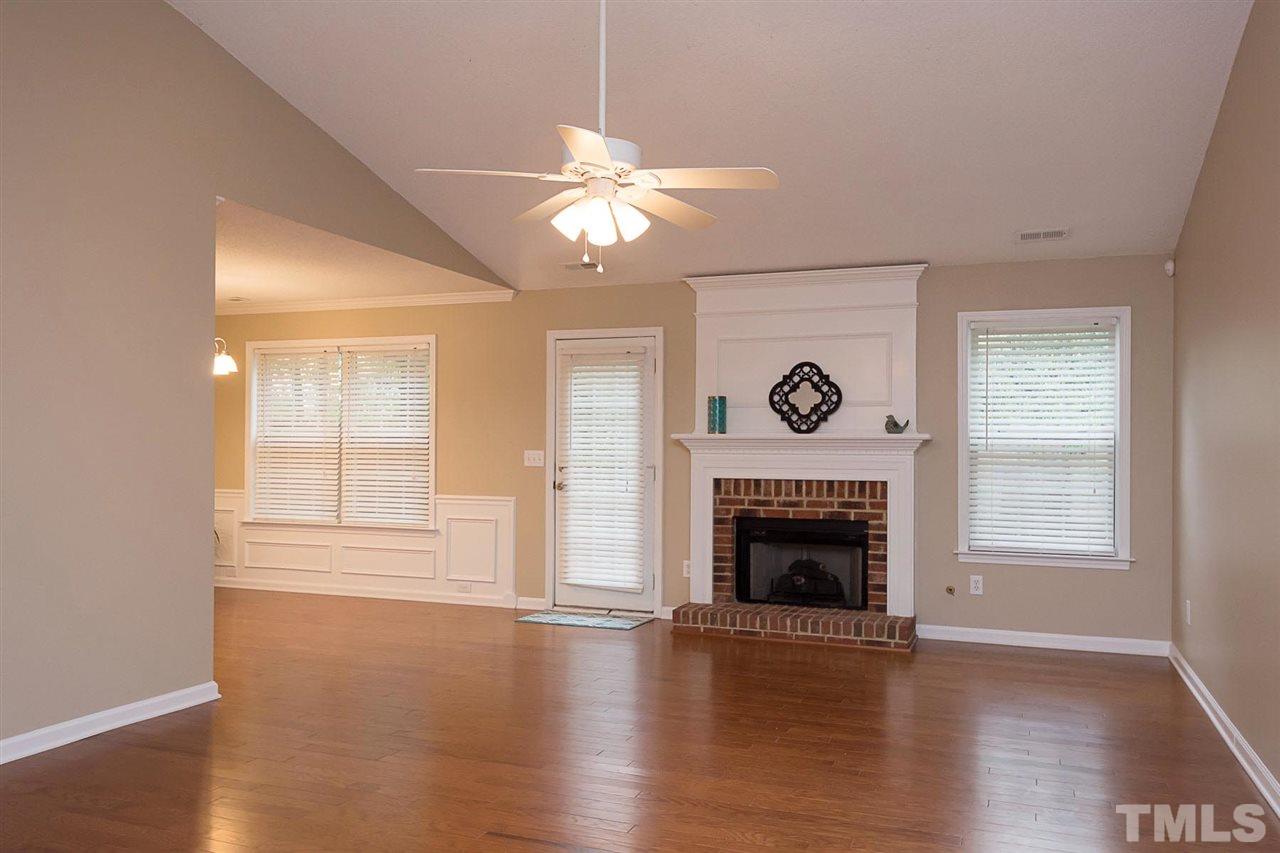 3809 Toyon Drive Raleigh, NC 27616 - Photo 1 of 20 an empty room with wooden floor fireplace and windows