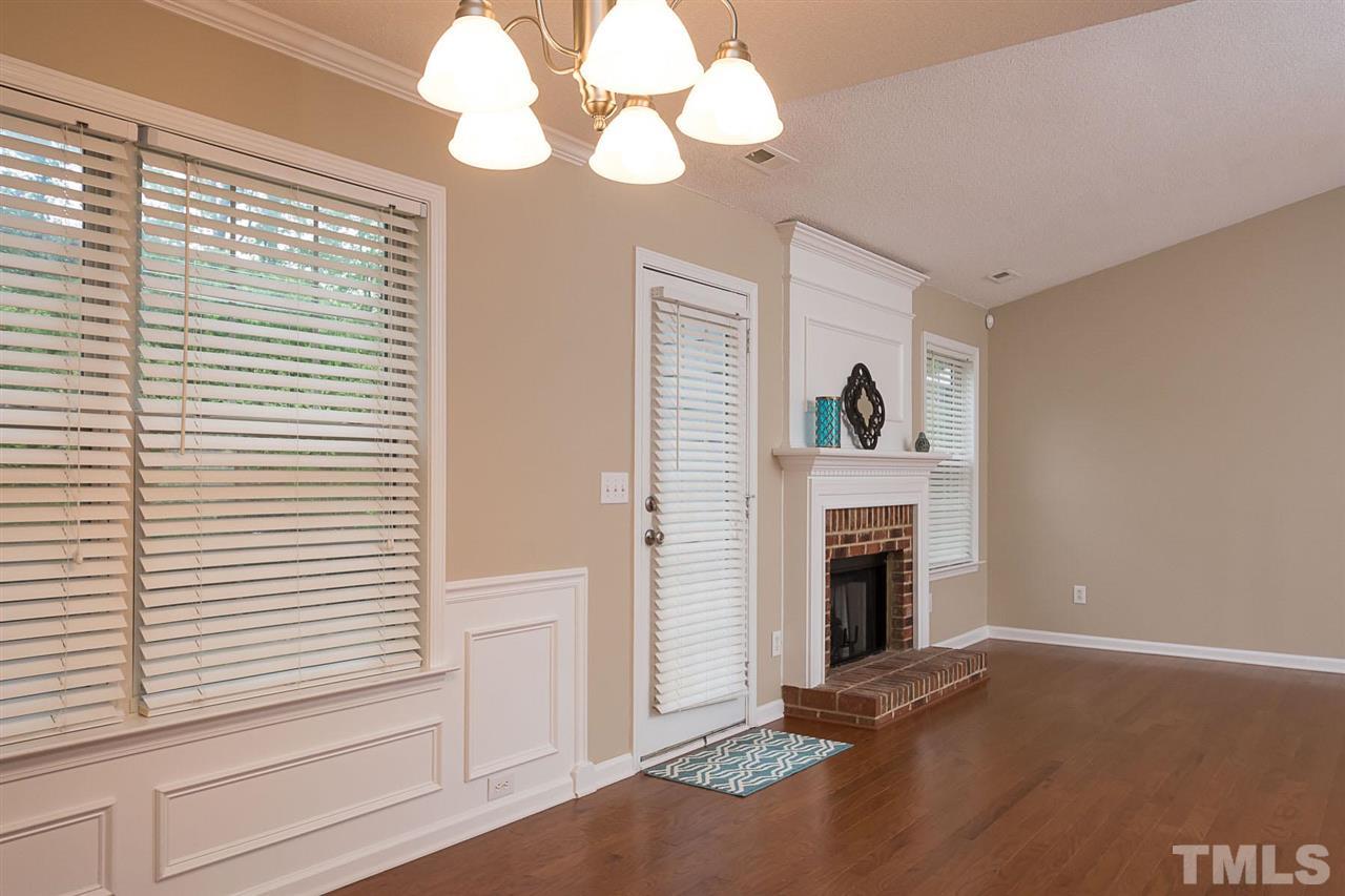3809 Toyon Drive Raleigh, NC 27616 - Photo 11 of 20 a view of a livingroom with a fireplace a chandelier and stairs