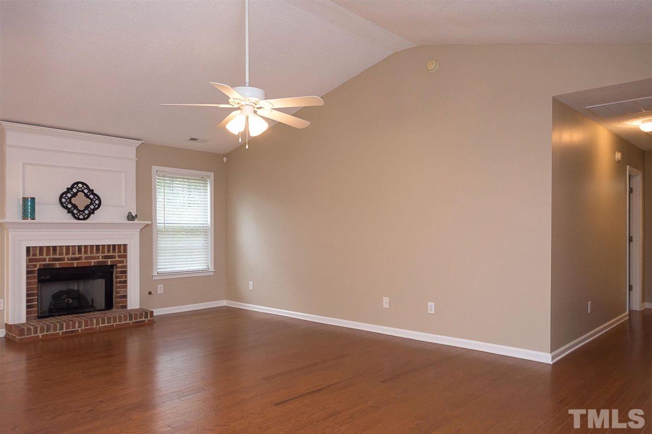 3809 Toyon Drive Raleigh, NC 27616 - Photo 4 of 20 a view of a livingroom with a fireplace a ceiling fan and hardwood floor
