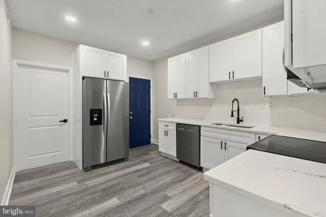 a kitchen with a refrigerator sink and cabinets